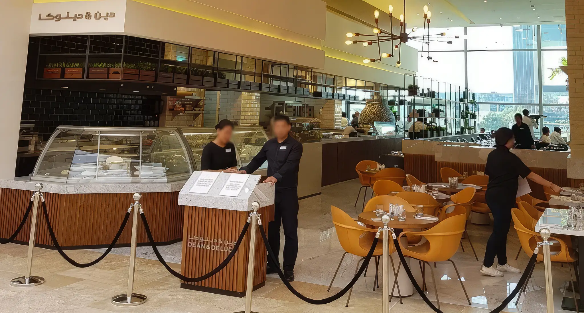 A view inside Dean & Deluca in Bahrain, revealing individuals gathered and conversing within the establishment.