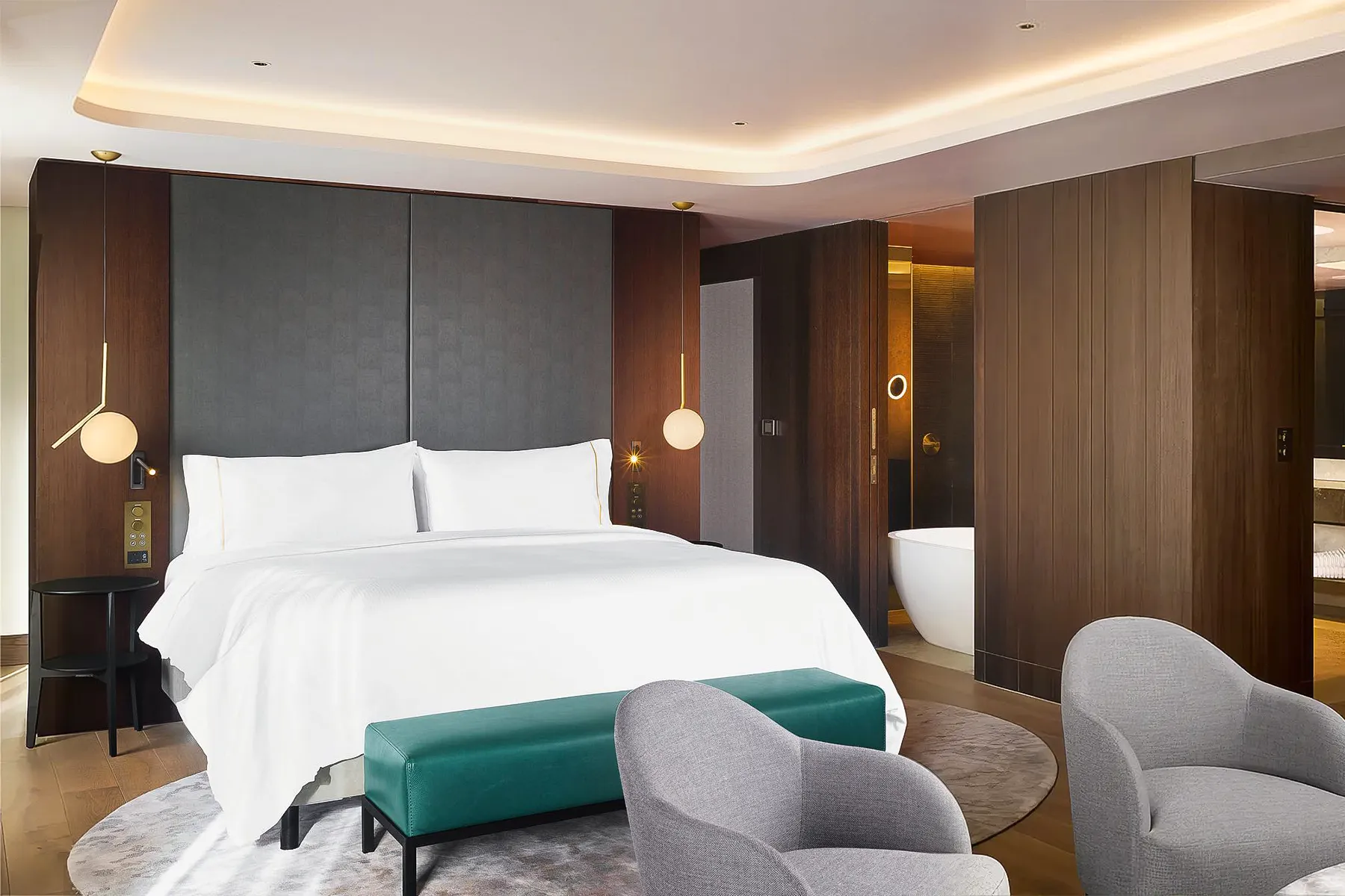 a modern hotel room with a bed and lounge chairs contract furniture - interior design Uk