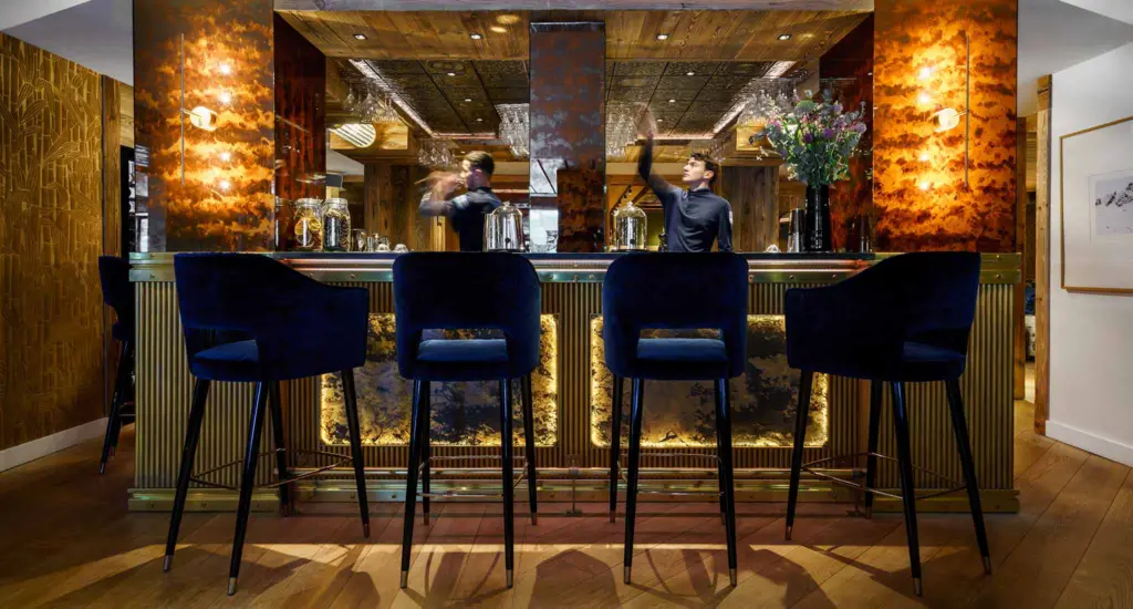 Elegant gold and blue decorations enhance the ambiance of the bar at Hotel LA SIVOLIÈRE, France.