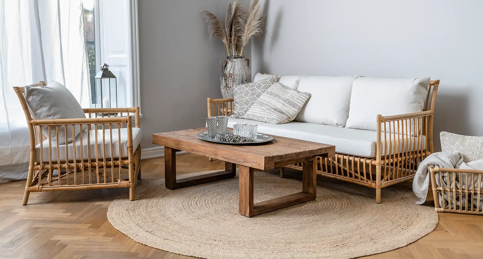 A tastefully decorated living room in Guernsey featuring elegant wicker furniture and a cozy rug.