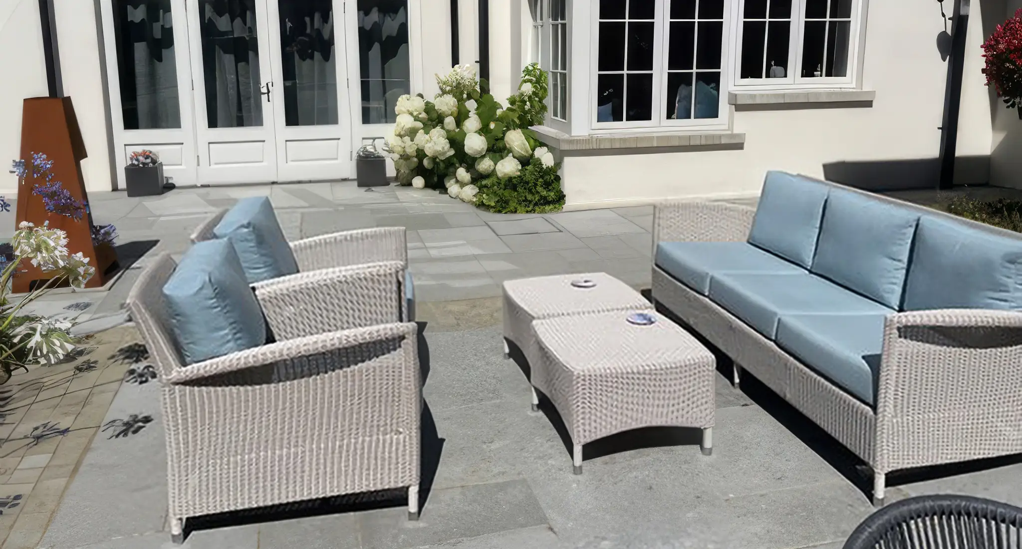 Residential patio in Northern Ireland furnished with wicker furniture and coffee tables for outdoor relaxation.